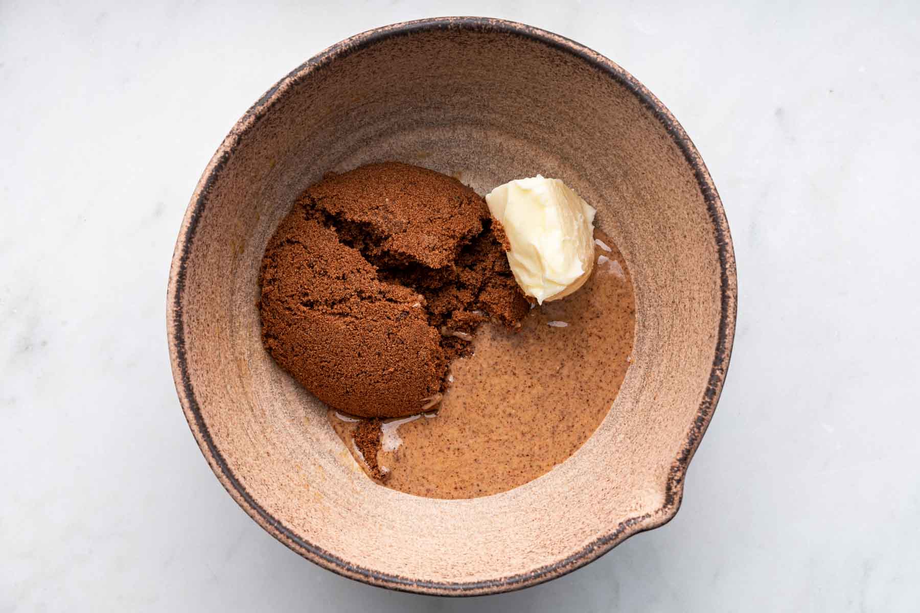 Brown bowl with butter, almond butter, and brown sugar.