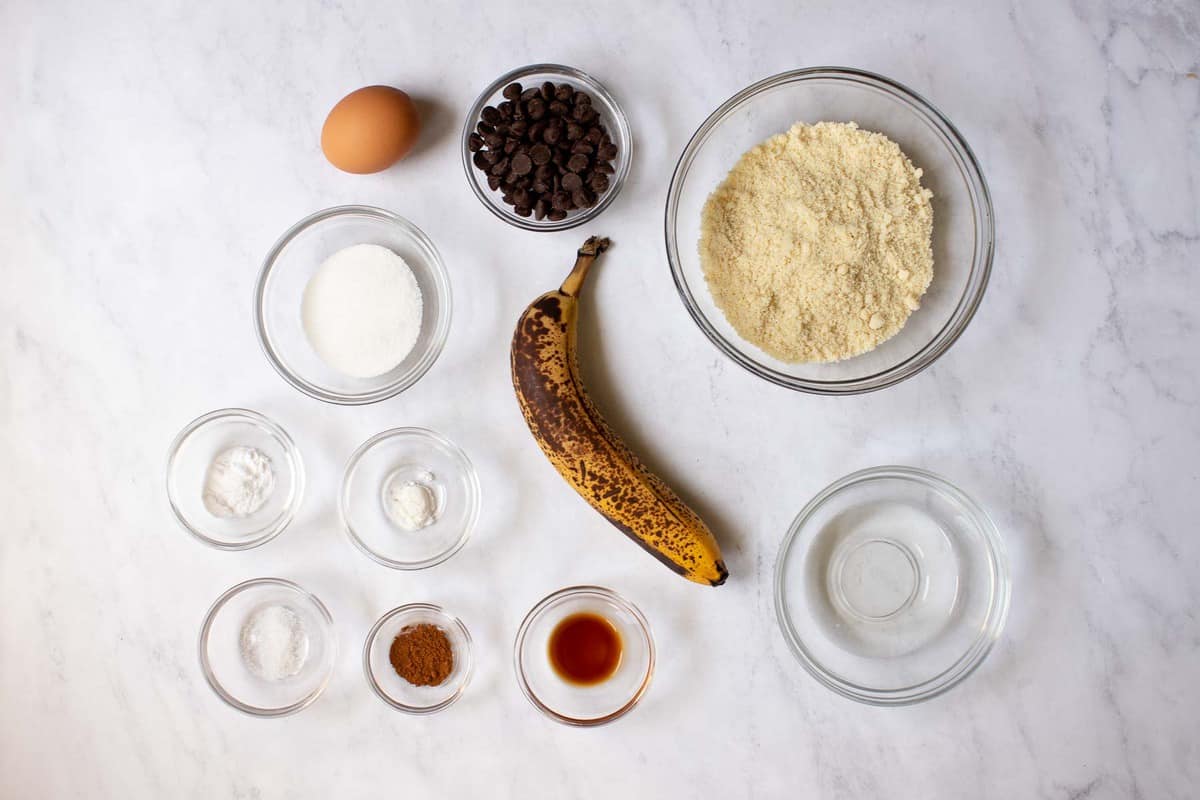 Ingredients for almond flour banana muffins on marble table.