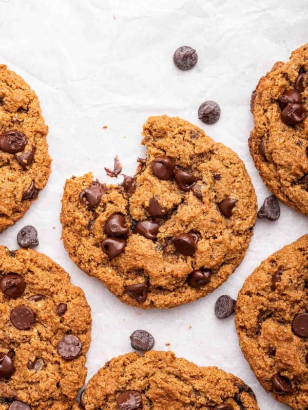 Overhead shot of almond flour chocolate chip cookies, one missing a bite.