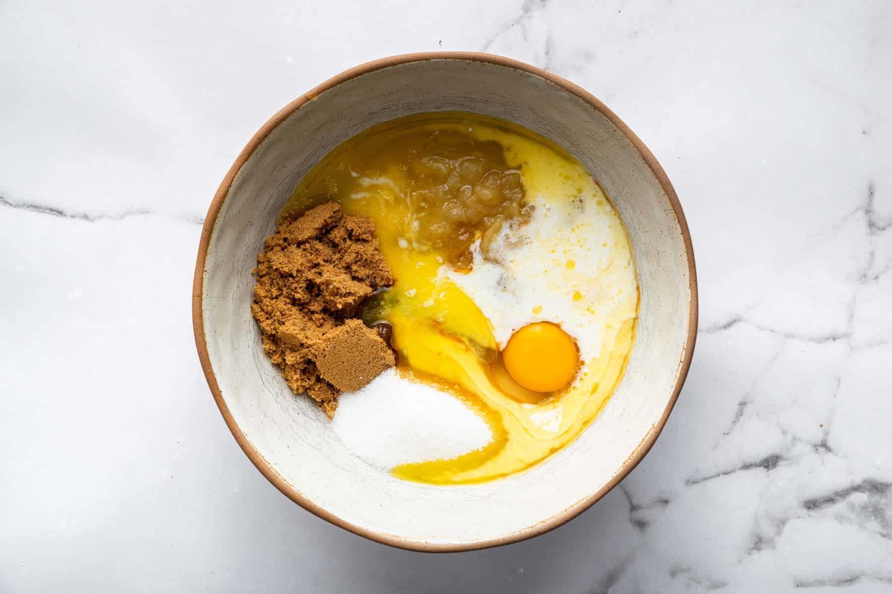 Bowl with melted butter, egg, and sugars.