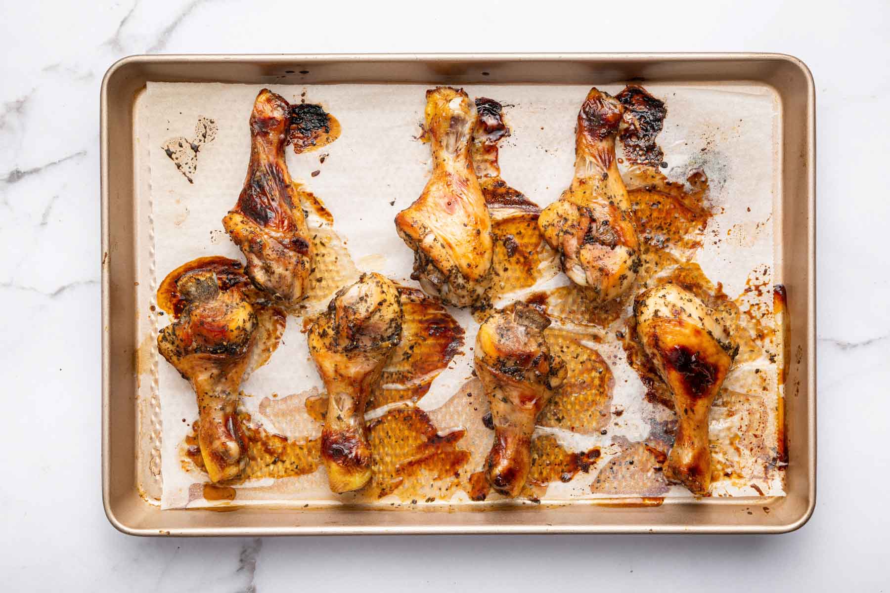 Golden brown drumsticks on a baking sheet.