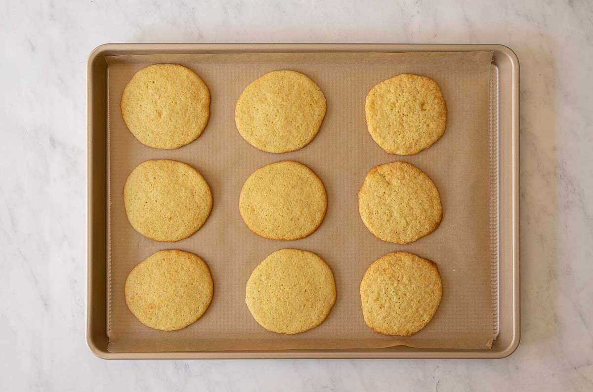 Nine baked cookies on a baking sheet.