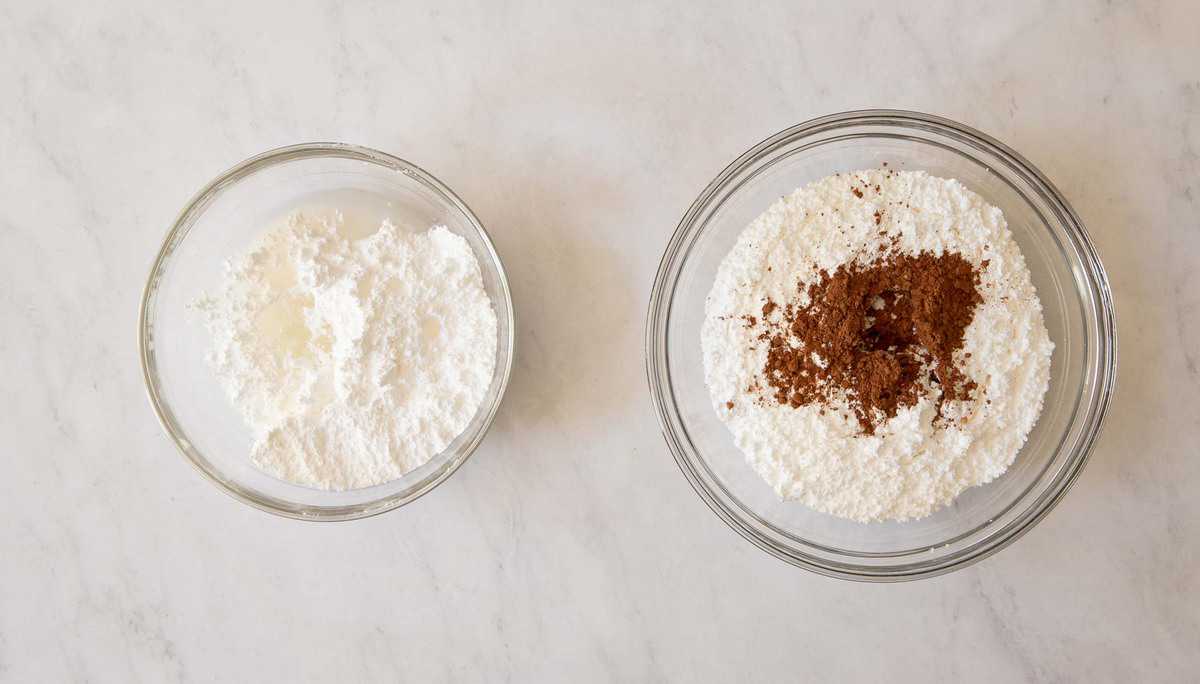 Bowl of vanilla icing next to chocolate icing.