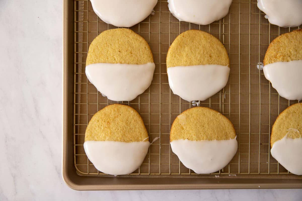 Cookies half dipped in white frosting.