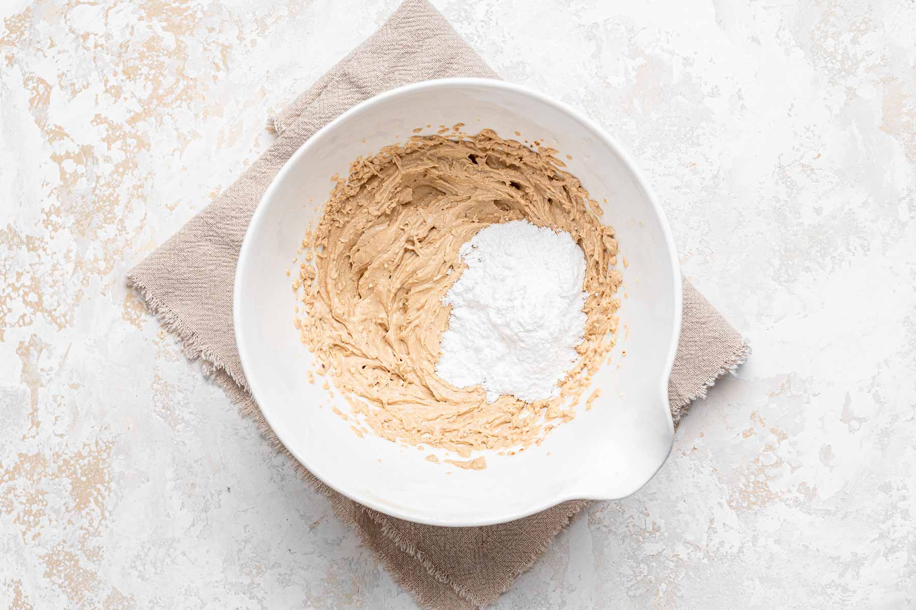 Cupcake frosting with powdered sugar being added.