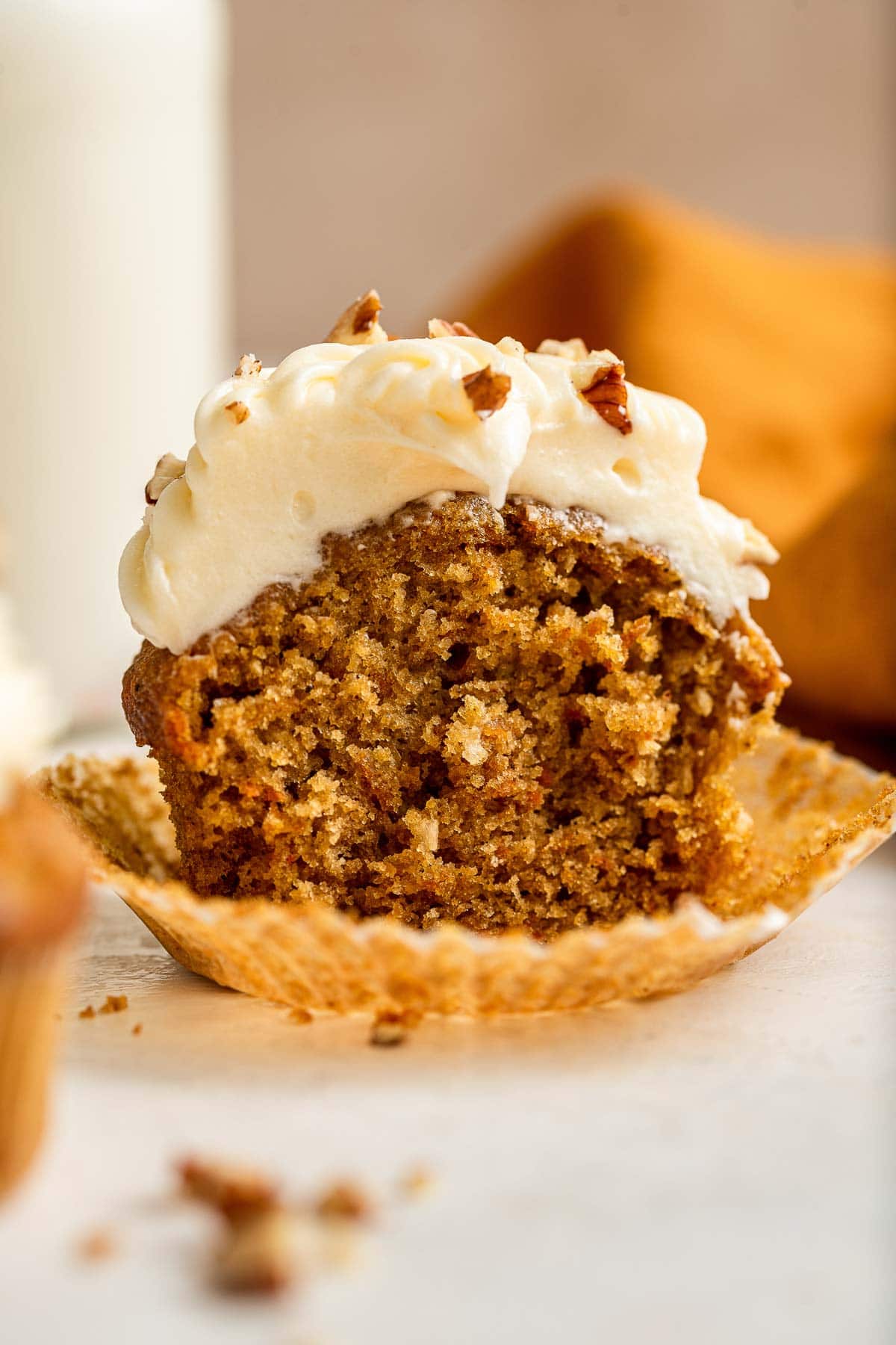 Carrot cake cupcake, sliced in half to show cake crumb.