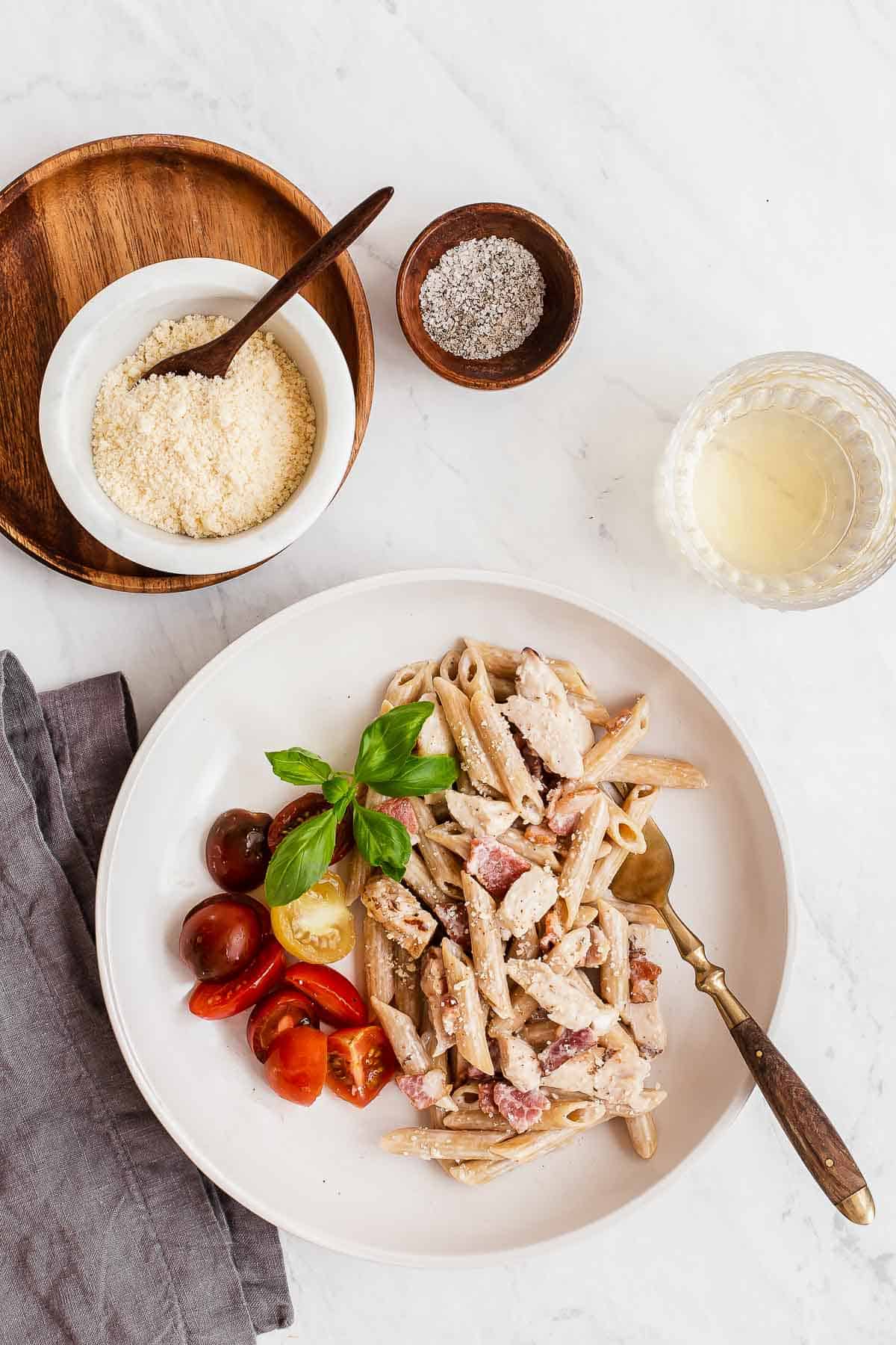 overhead photo of pasta on plate with bacon chicken and tomatoes