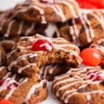 Macro shot of chocolate cookies with cherry on top and pink maraschino drizzle.