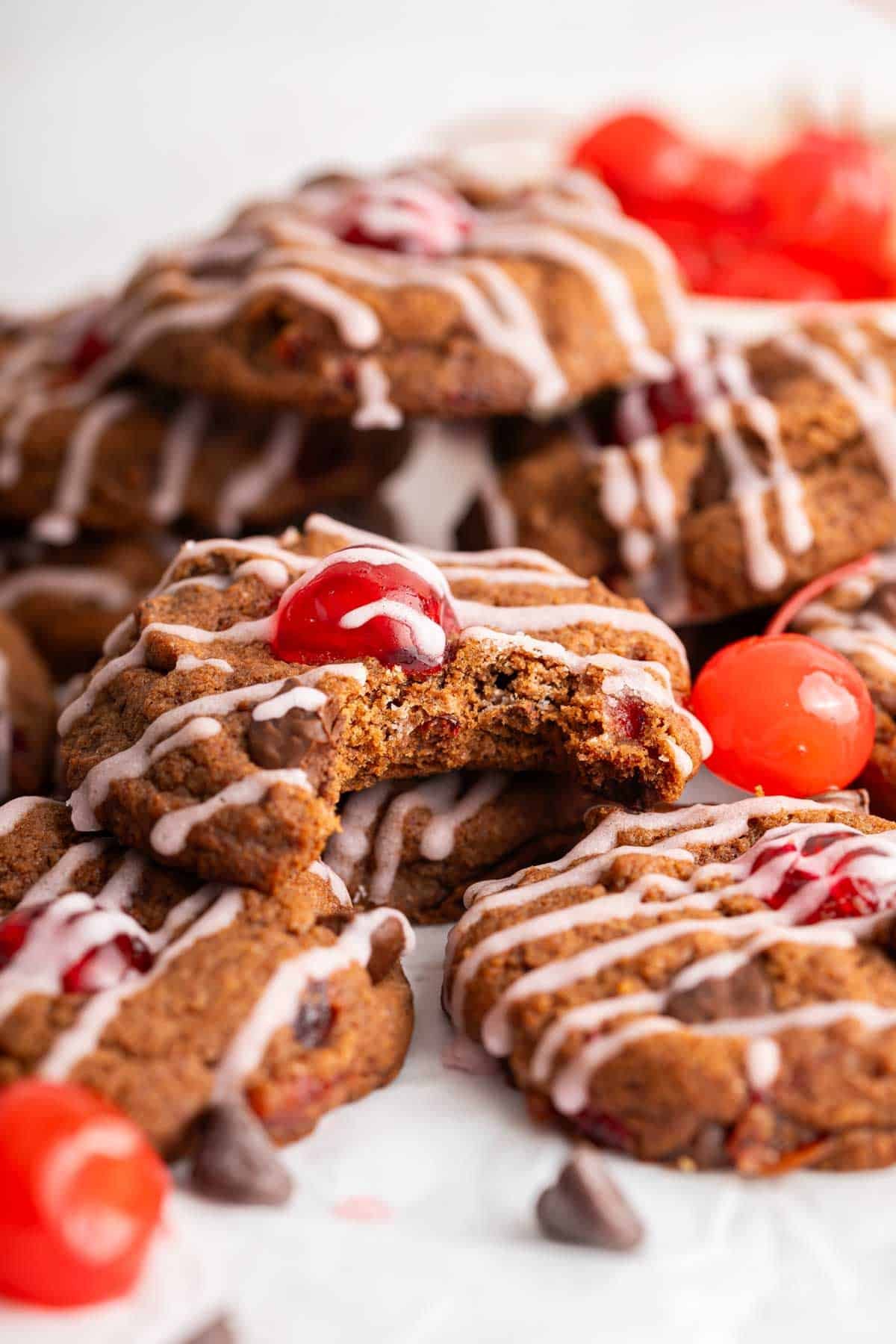 Macro shot of chocolate cookies with cherry on top and pink maraschino drizzle.
