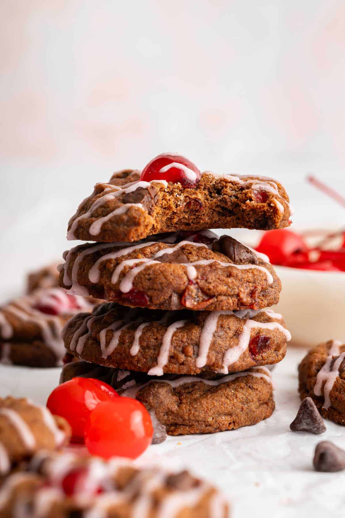 Stack of cherry chocolate cookies drizzled in pink glaze.