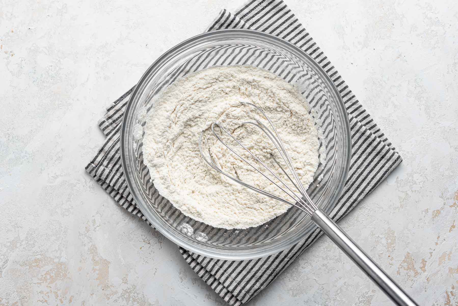 Whisking dry ingredients in a bowl.