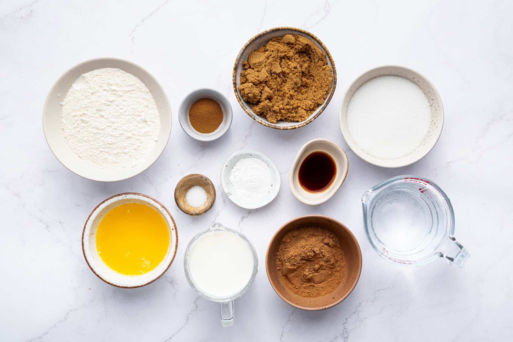 Small bowls of brown sugar, melted butter, cocoa powder, and flour.