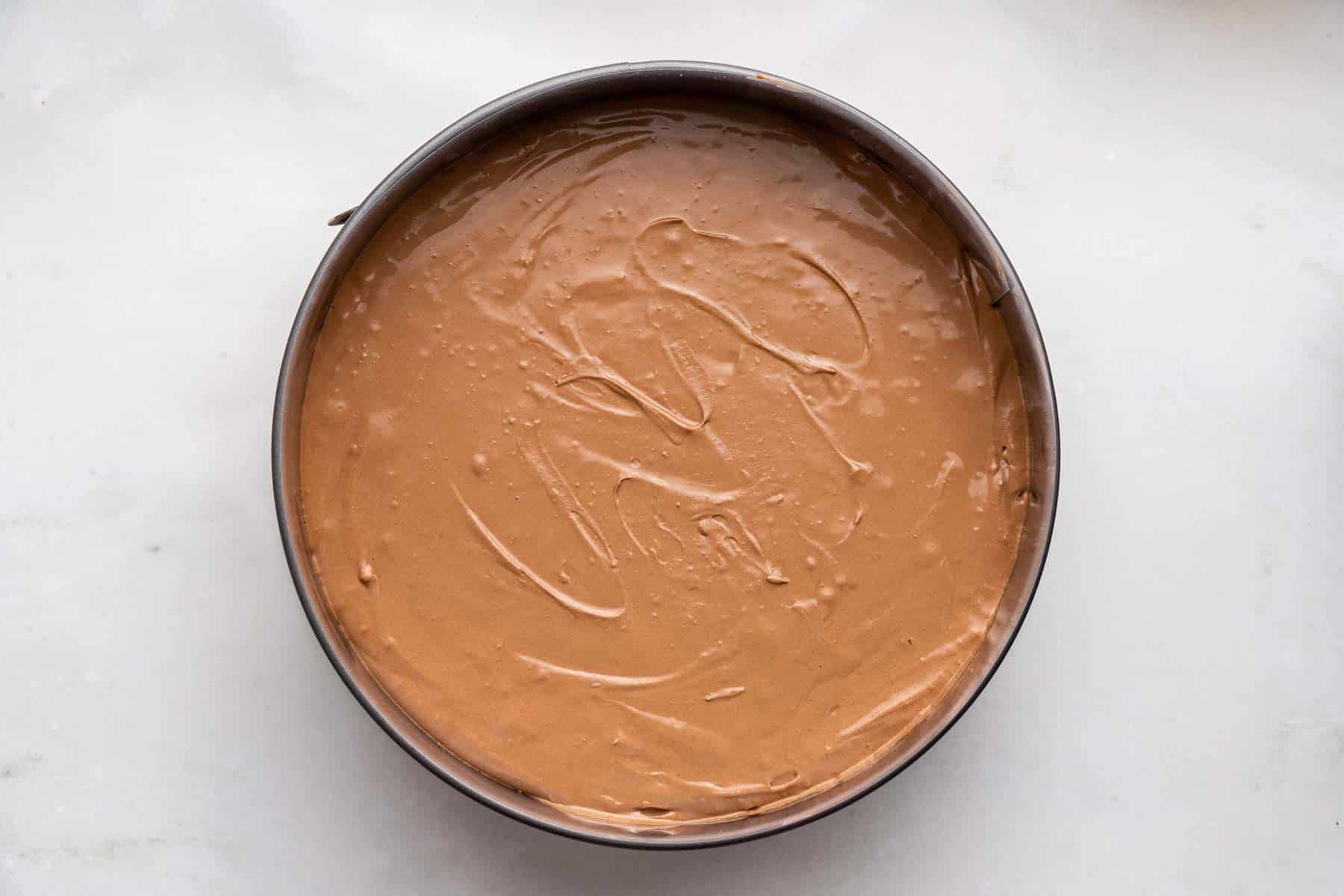 Fluffy brown dessert in a round springform pan.