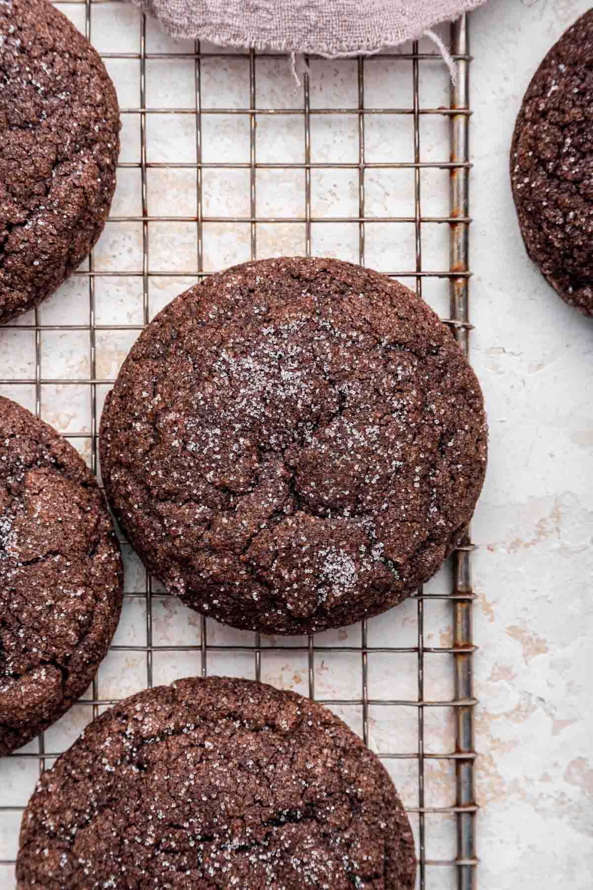 Overhead shot of chocolate sugar cookies on metal cooling rack.