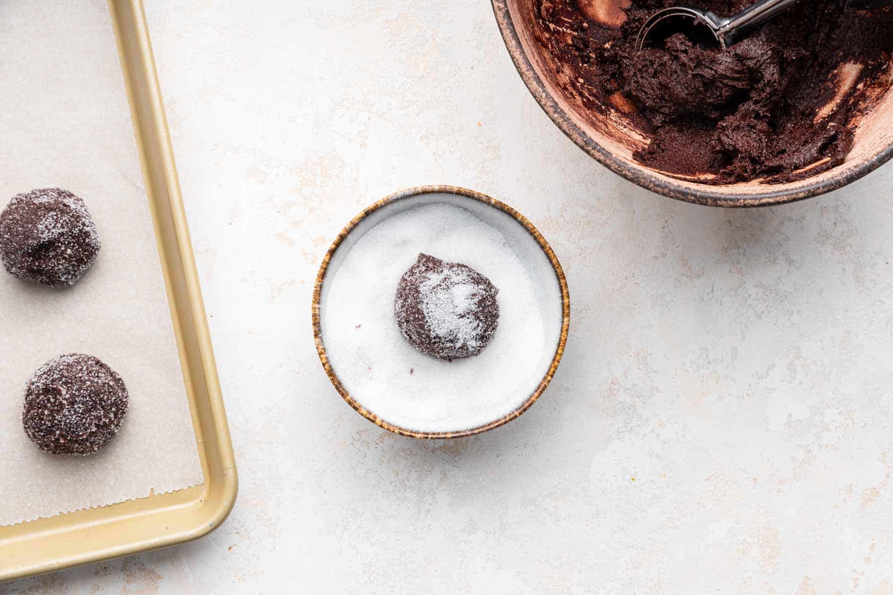 Round brown ball in bowl of white sugar.