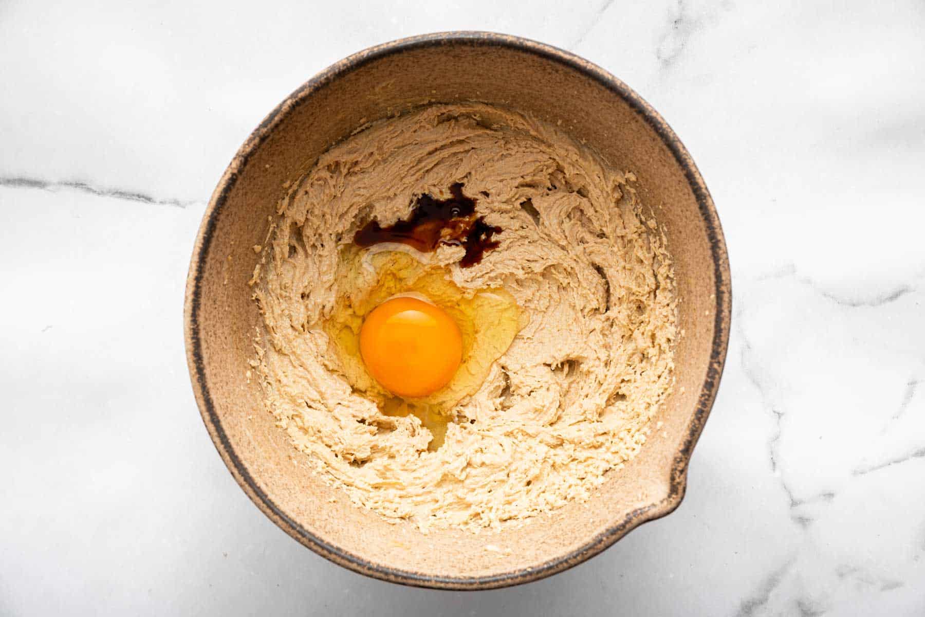 Whipped tan batter with a whole egg and splash of vanilla on top.