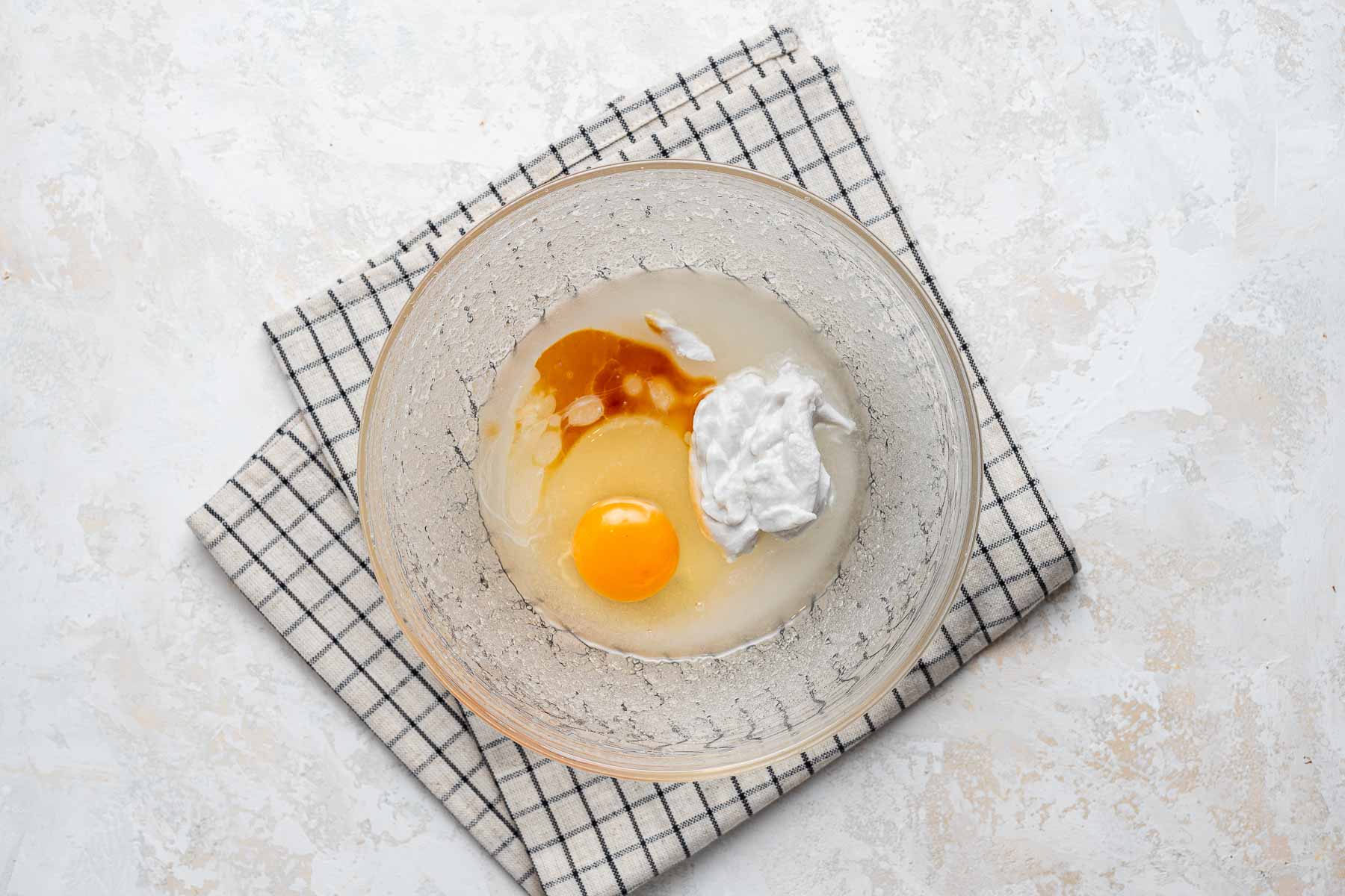 Egg, coconut milk and vanilla extract in bowl.