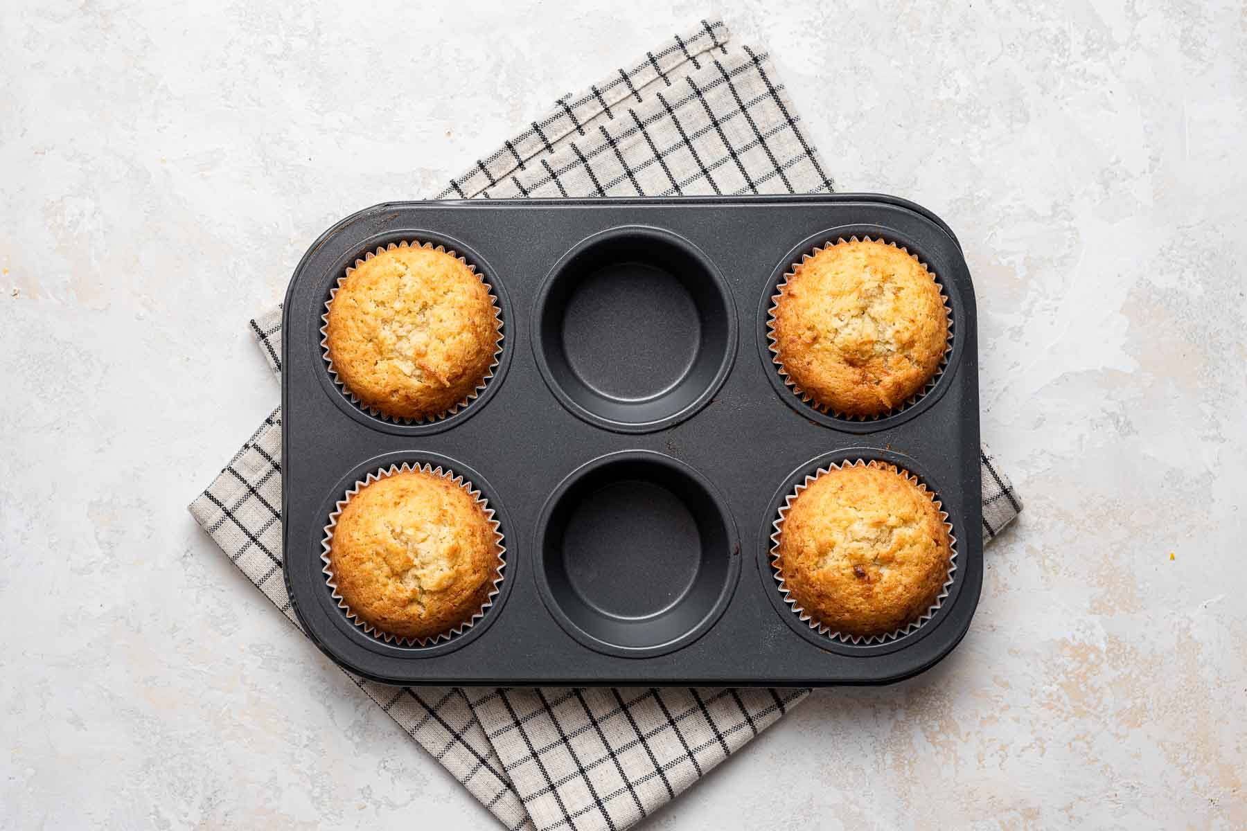 Cooked coconut cupcakes in pan.