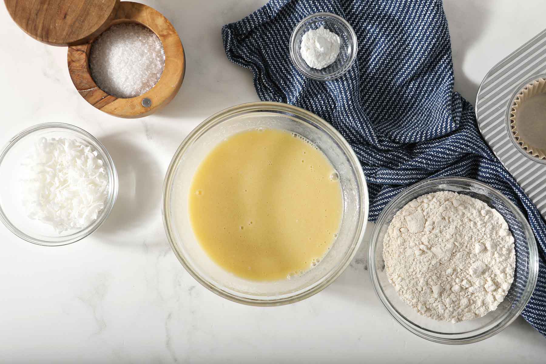 Coconut muffin batter in glass bowl.