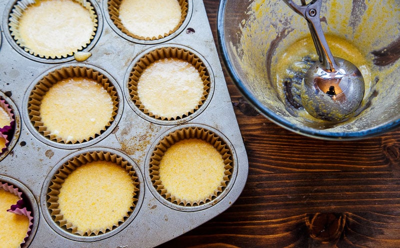 Muffin pan with liners and cornbread batter in it.