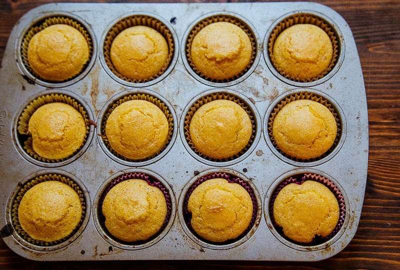 Muffin pan with cornbread muffins freshly baked.