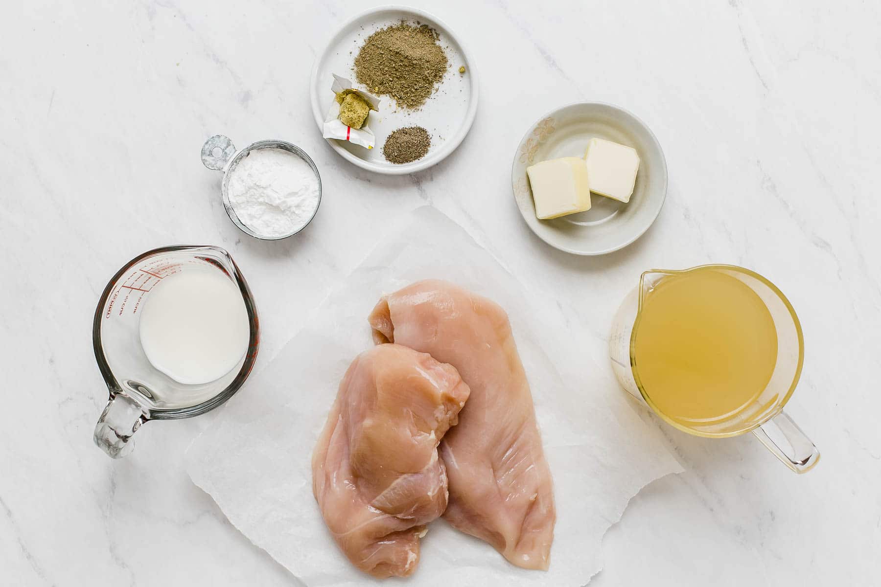Ingredients for chicken crockpot recipe on white table.
