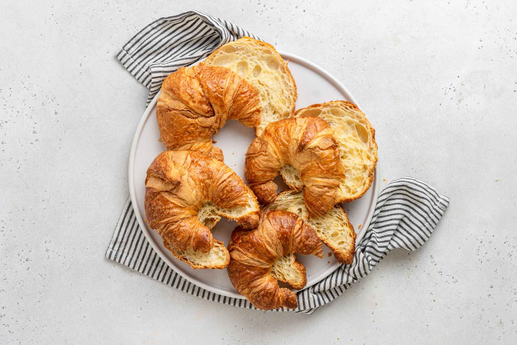 Croissants slice in half on plate.