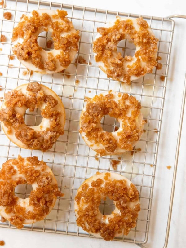 Wire tray with 6 crumb donuts on top.