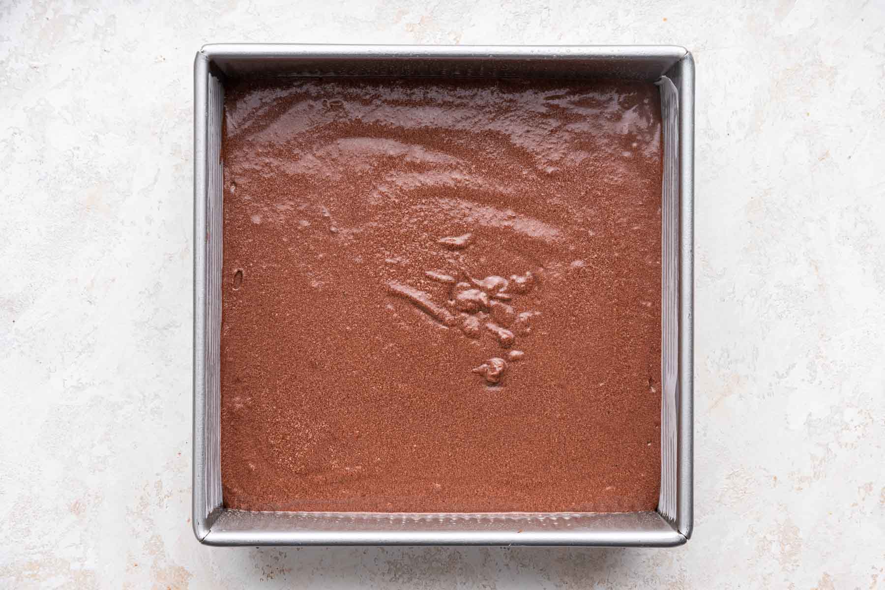 Raw Dr Pepper cake batter in a square pan, before baking.