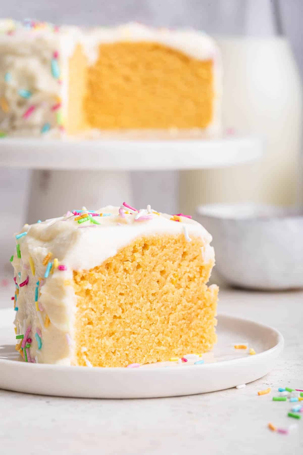 Slice of baby smash cake for first birthday cake with white frosting and sprinkles.