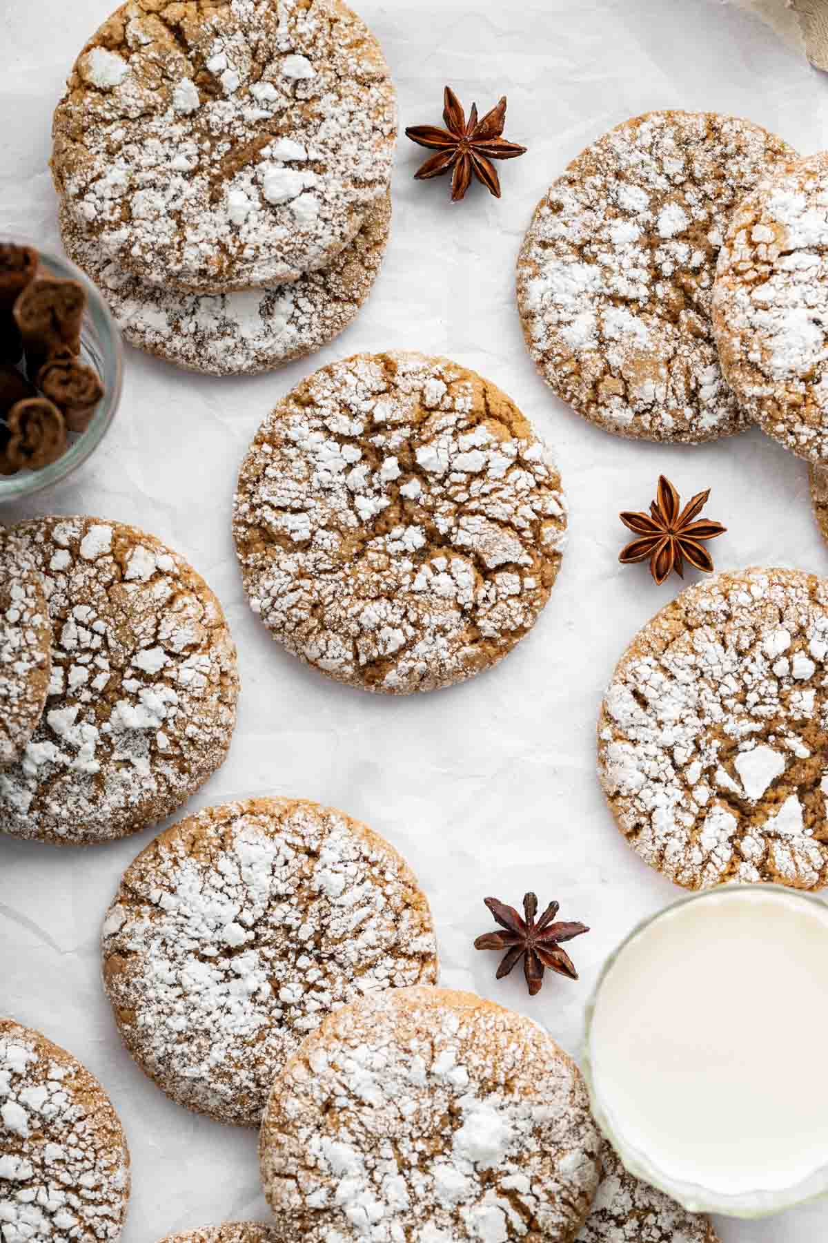Vertical image of cracked gingerbread cookies dusted with powdered sugar.