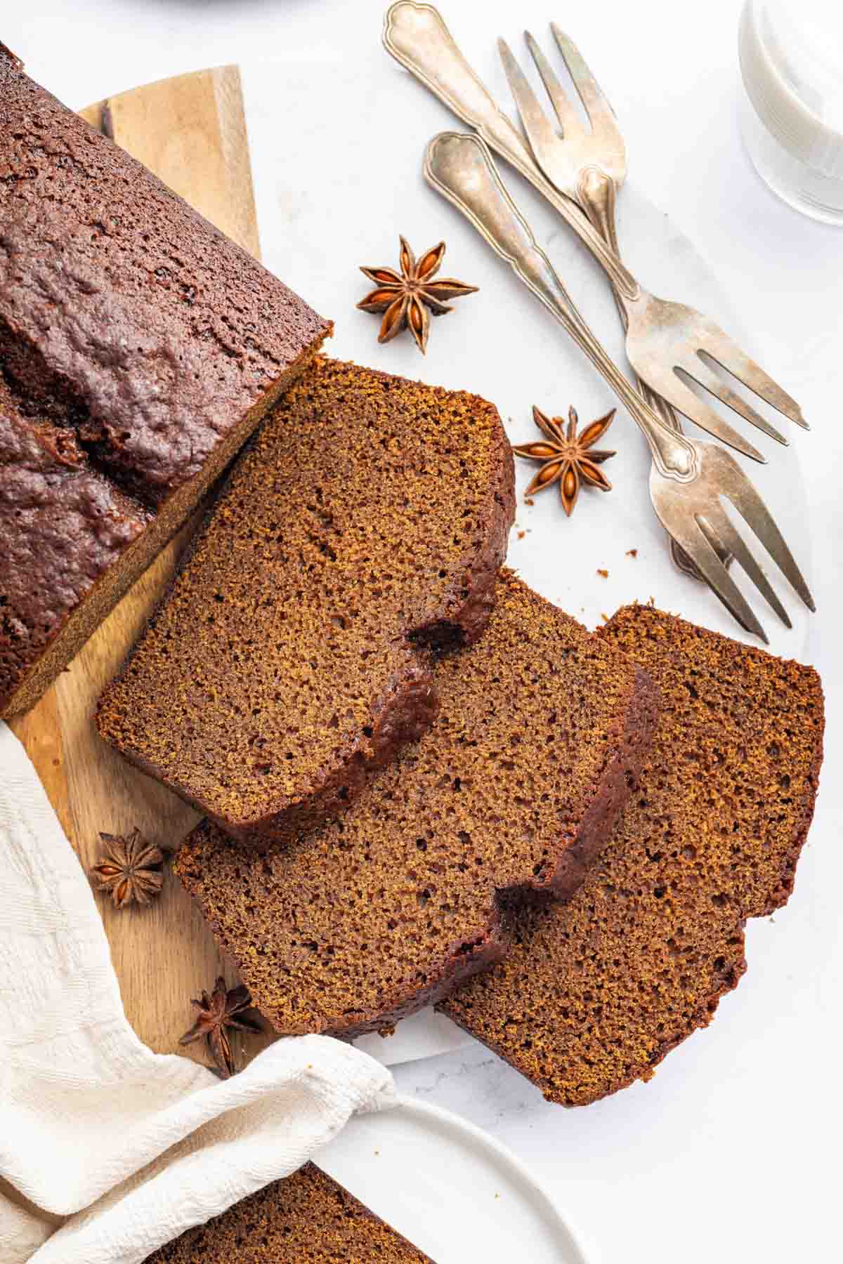 Overhead image of three slices of gingerbread cake loaf with forks on side.