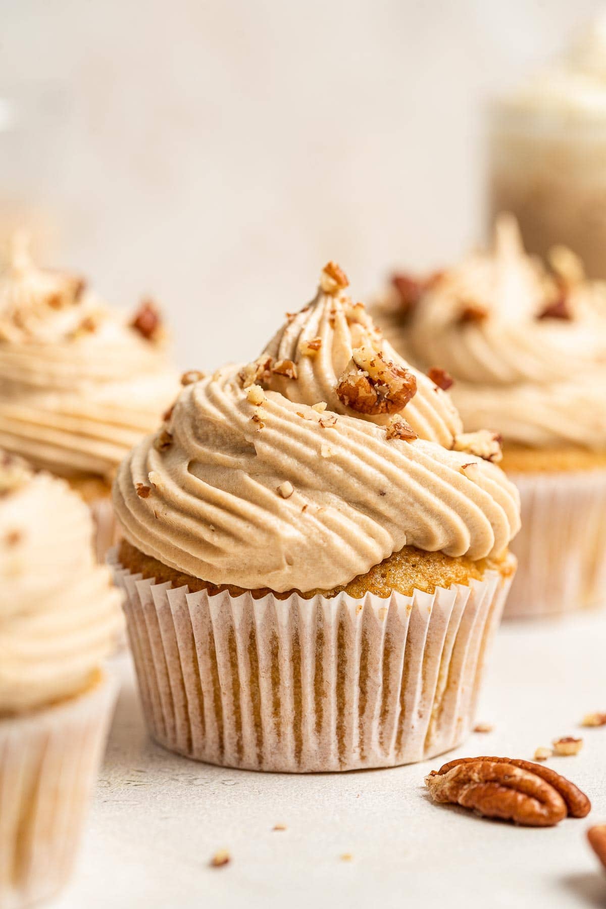 Four hummingbird cupcakes with pecans on top.