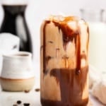 Vertical image of chocolate smeared iced mocha recipe with coffee beans.