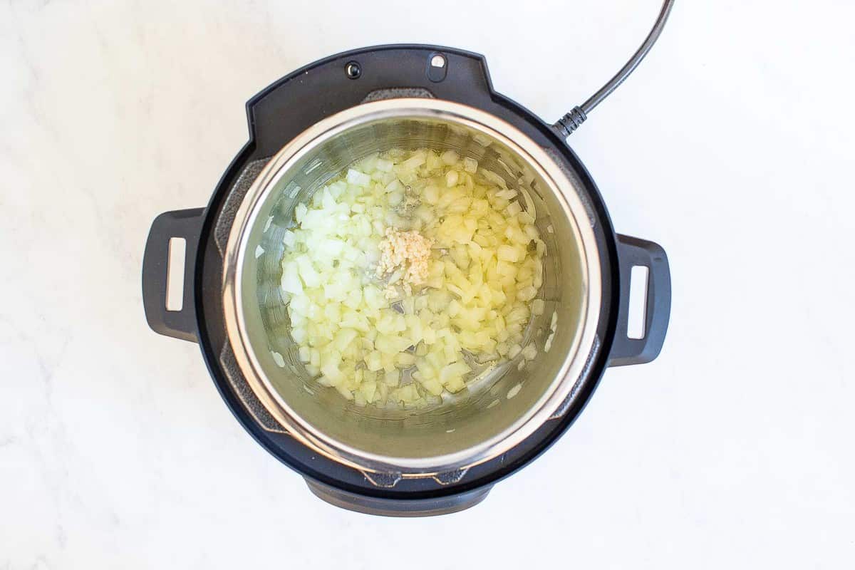 Instant pot with garlic and onions sautรฉing.