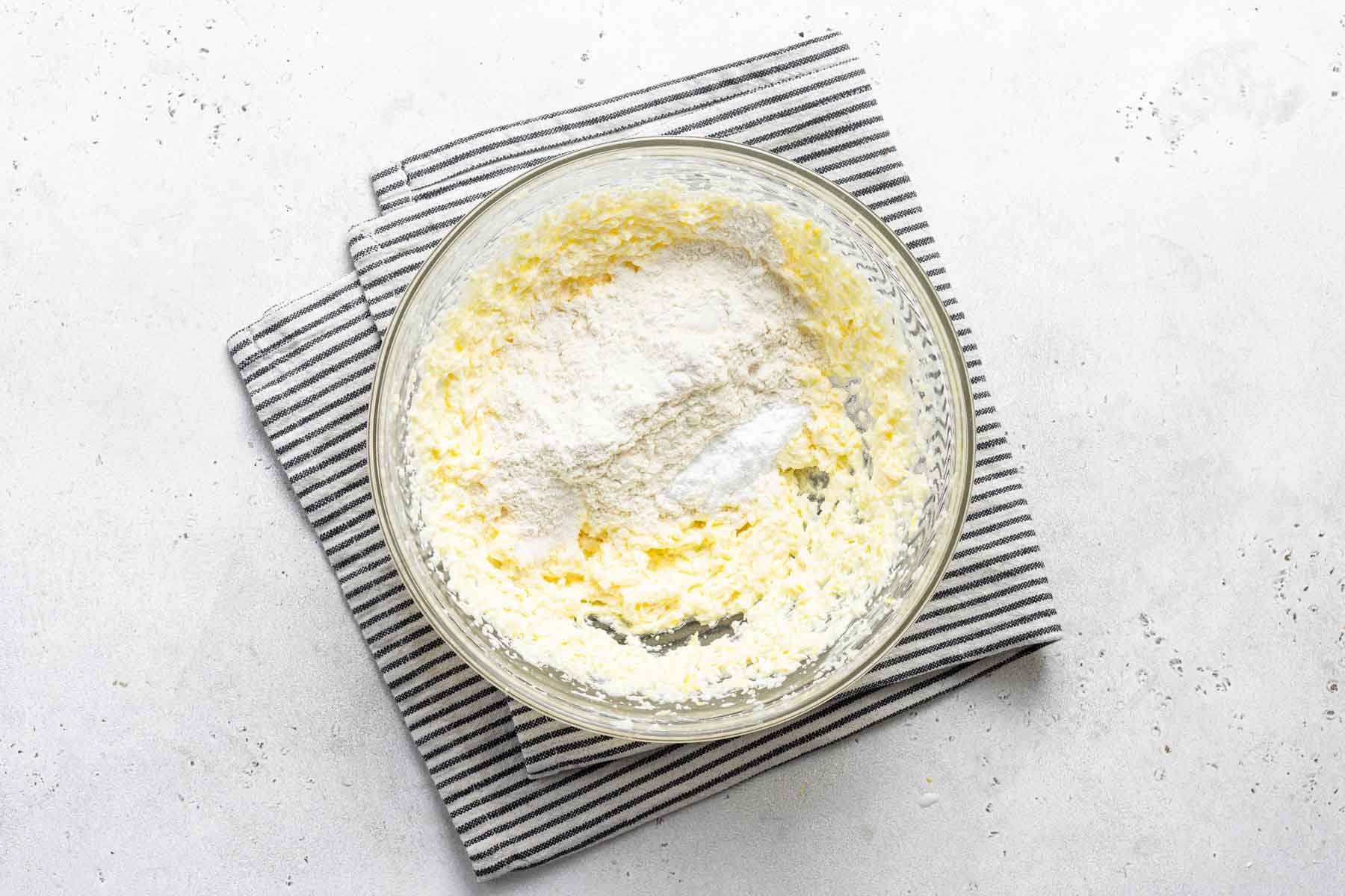 Lemon cupcake batter in bowl with dish towel.
