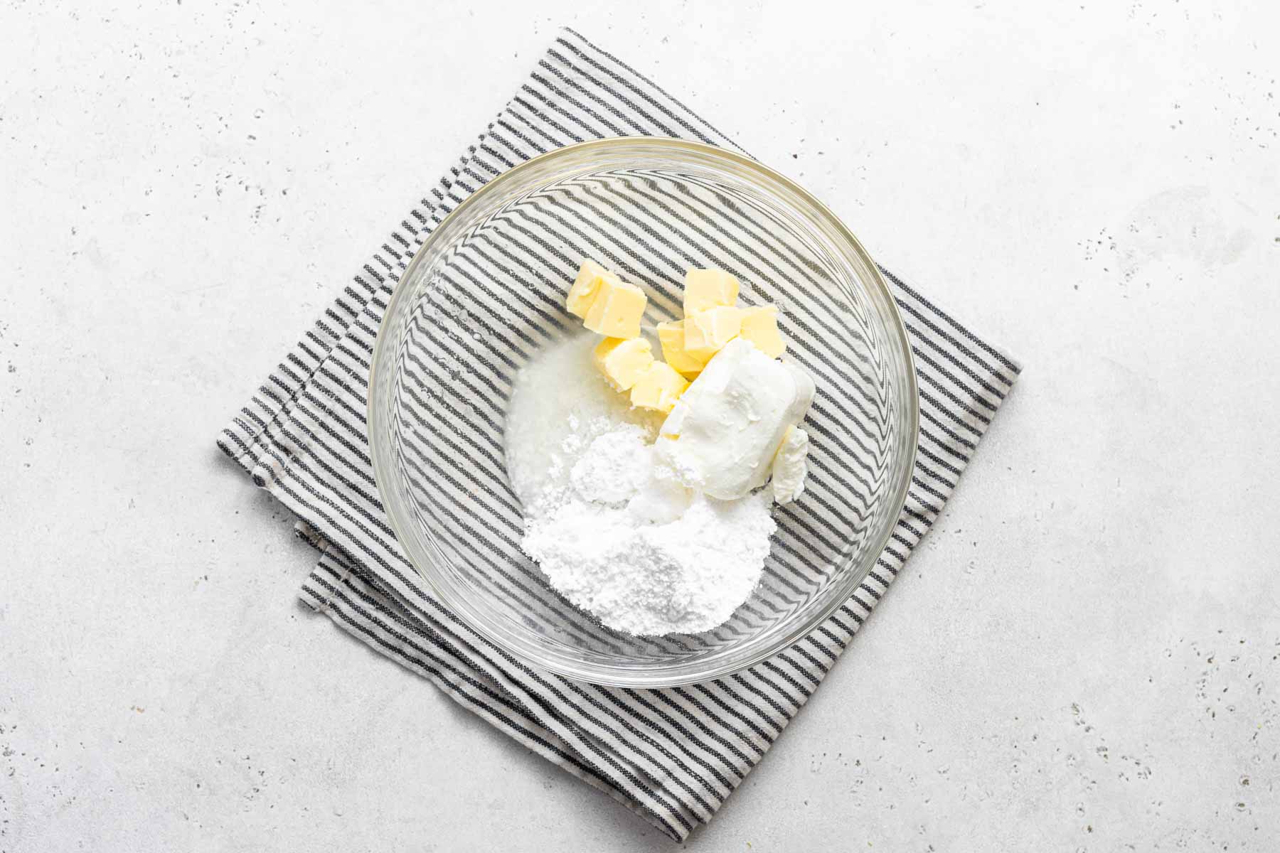 Ingredients for lemon cream cheese frosting in bowl.