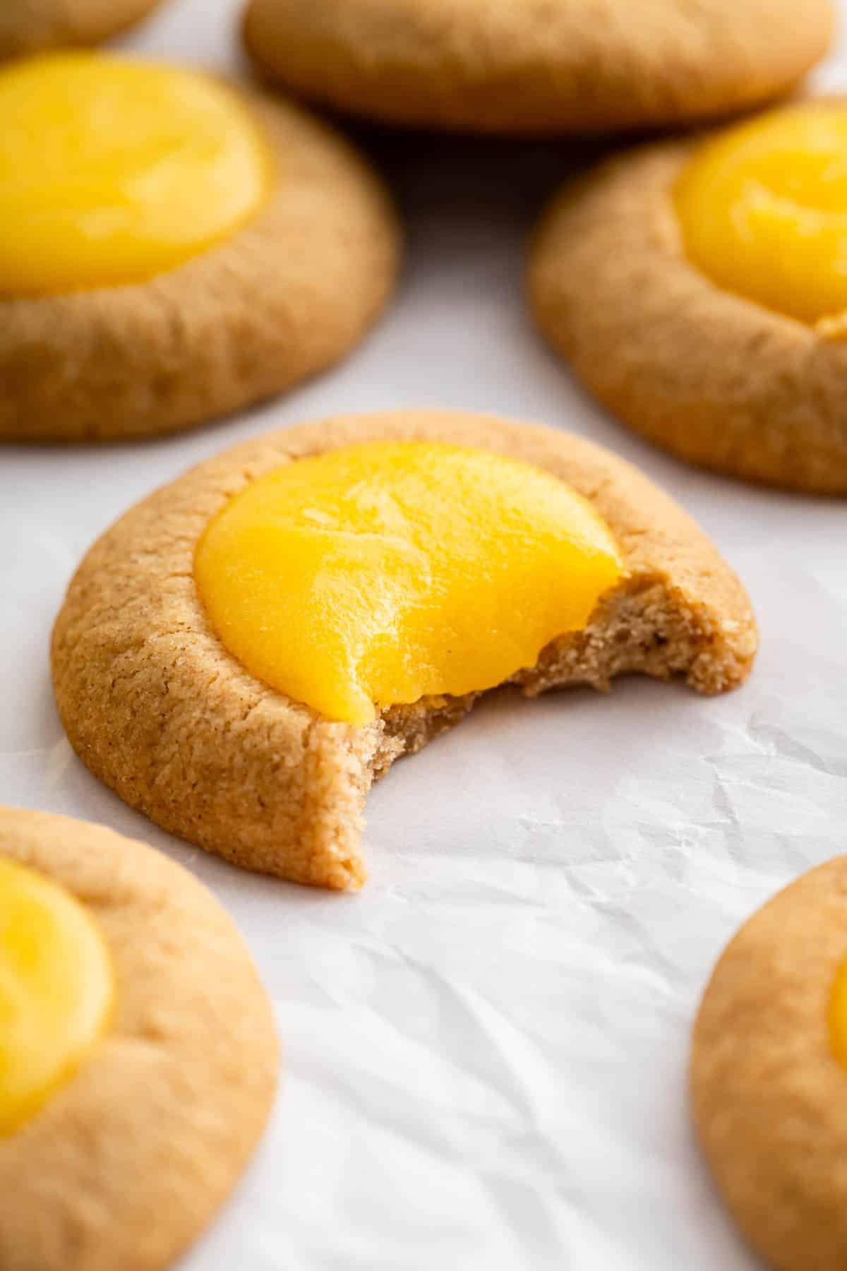 Macro image of thumbprint cookie with yellow lemon curd filling oozing out.