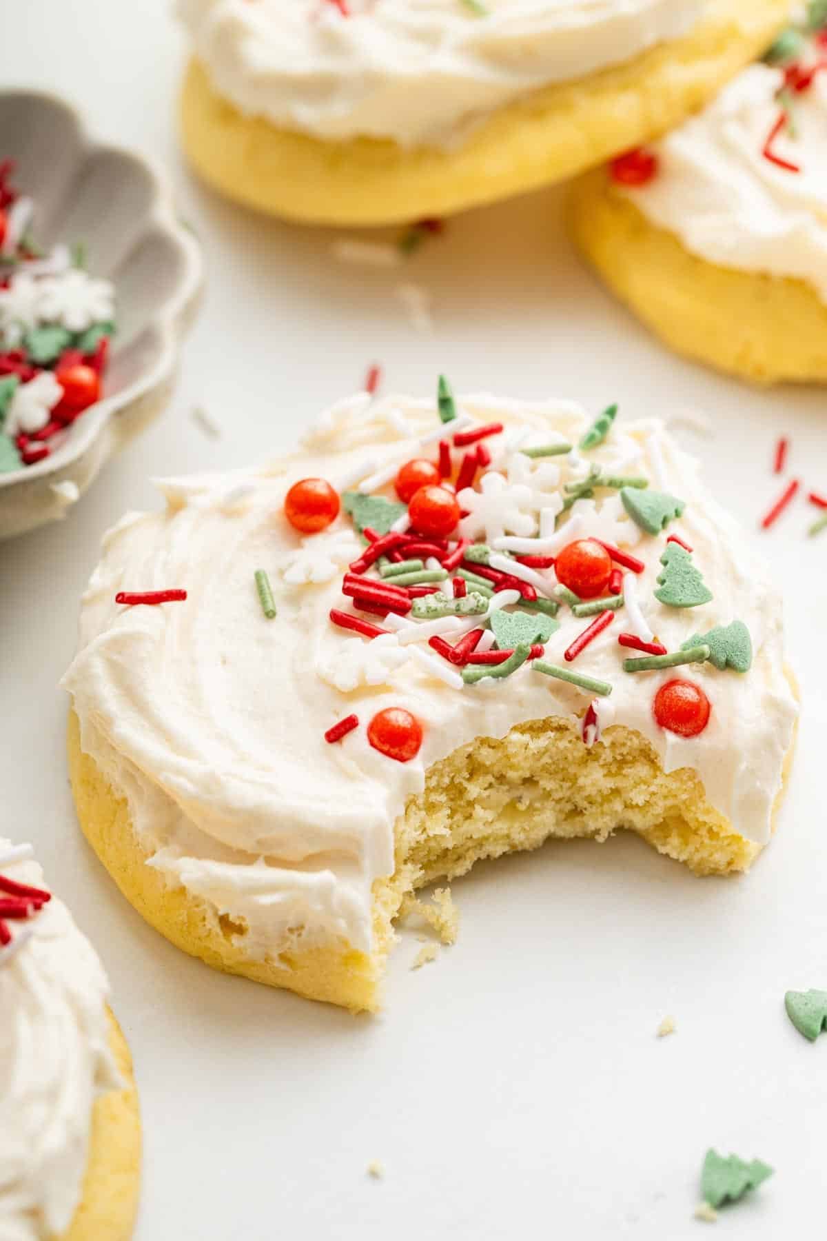 Lofthouse cookies with Christmas sprinkles and a bite missing from the front one.