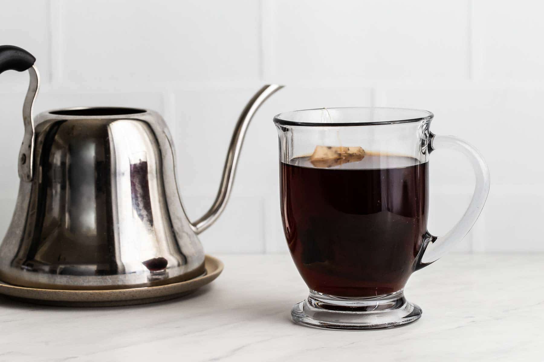 Earl Grey tea steeping in clear glass mug.