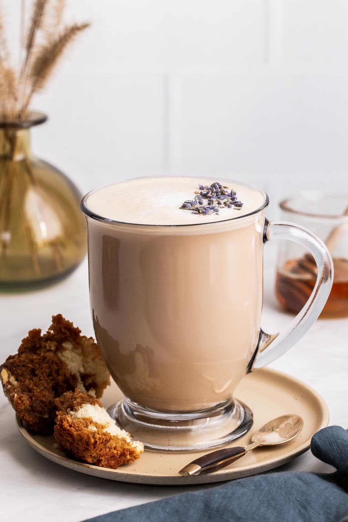 London fog tea latte in clear glass mug with lavender buds.
