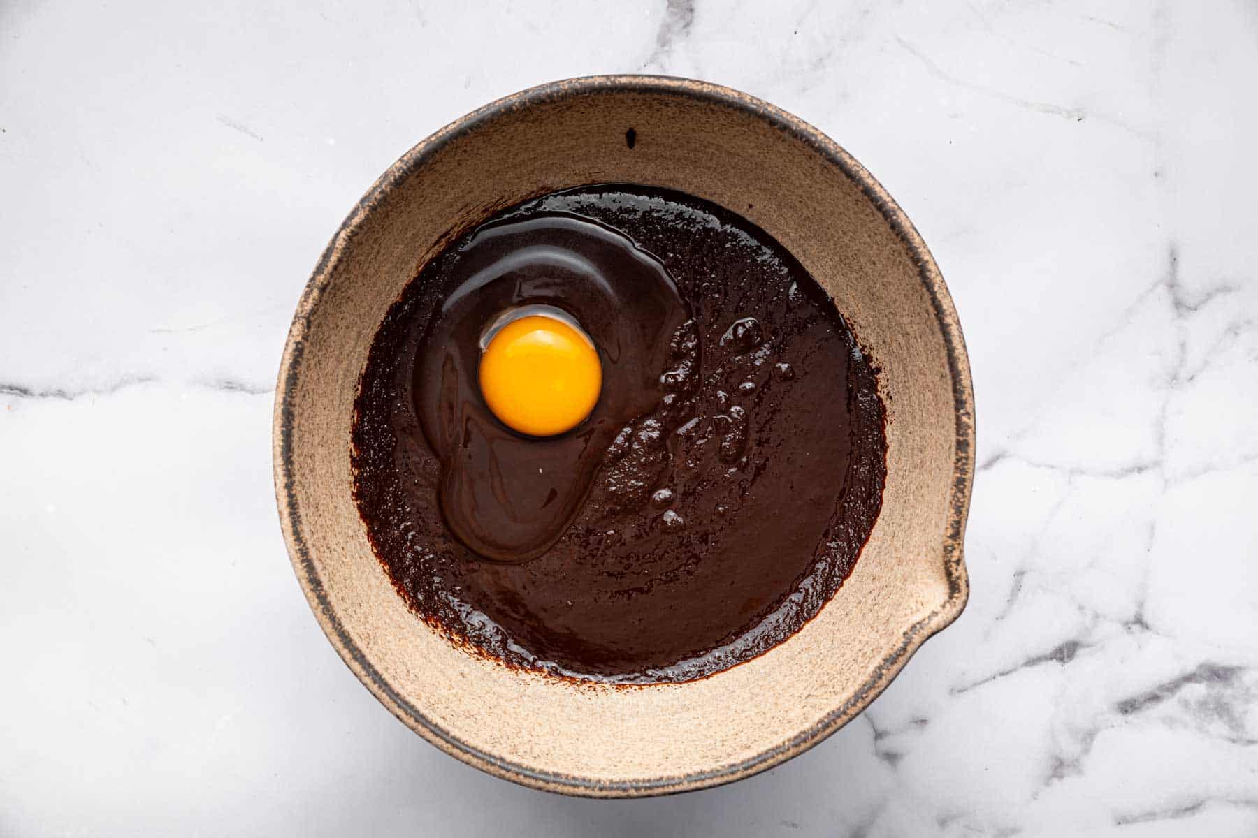 Chocolate batter with raw egg on top.