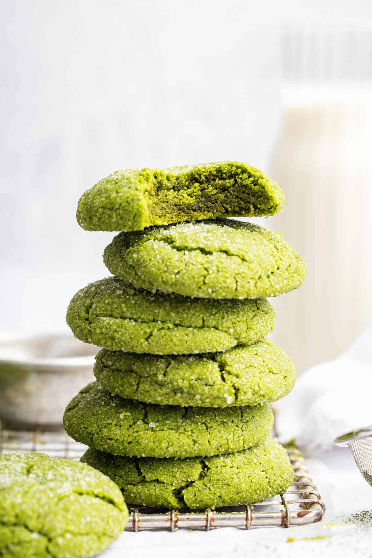 Stack of bright green matcha green tea cookies with bite missing from top one.