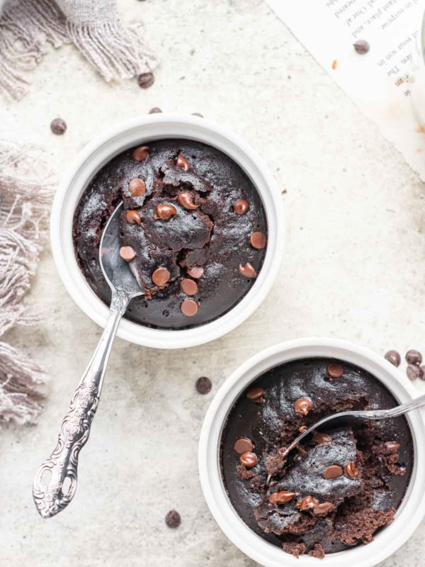 Two ramekins of microwave brownie pots with spoons.