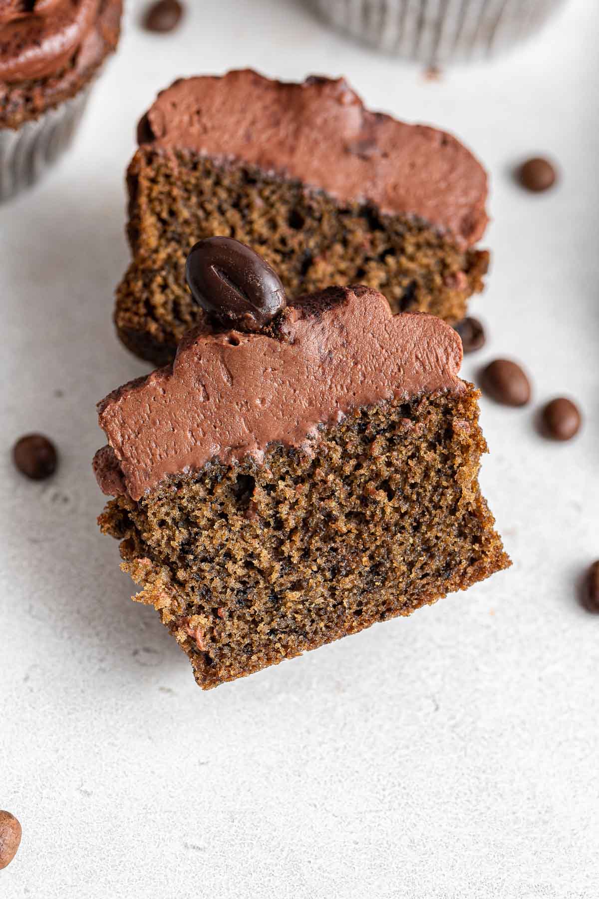 Chocolate coffee cupcake sliced in half and flat on plate.
