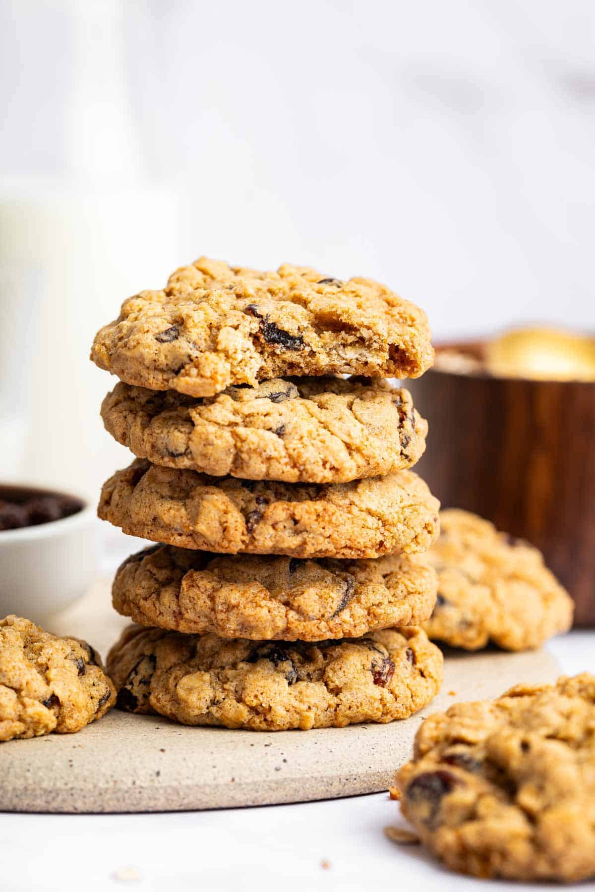 Stack of oatmeal raisin cookies with bite missing from the top one.