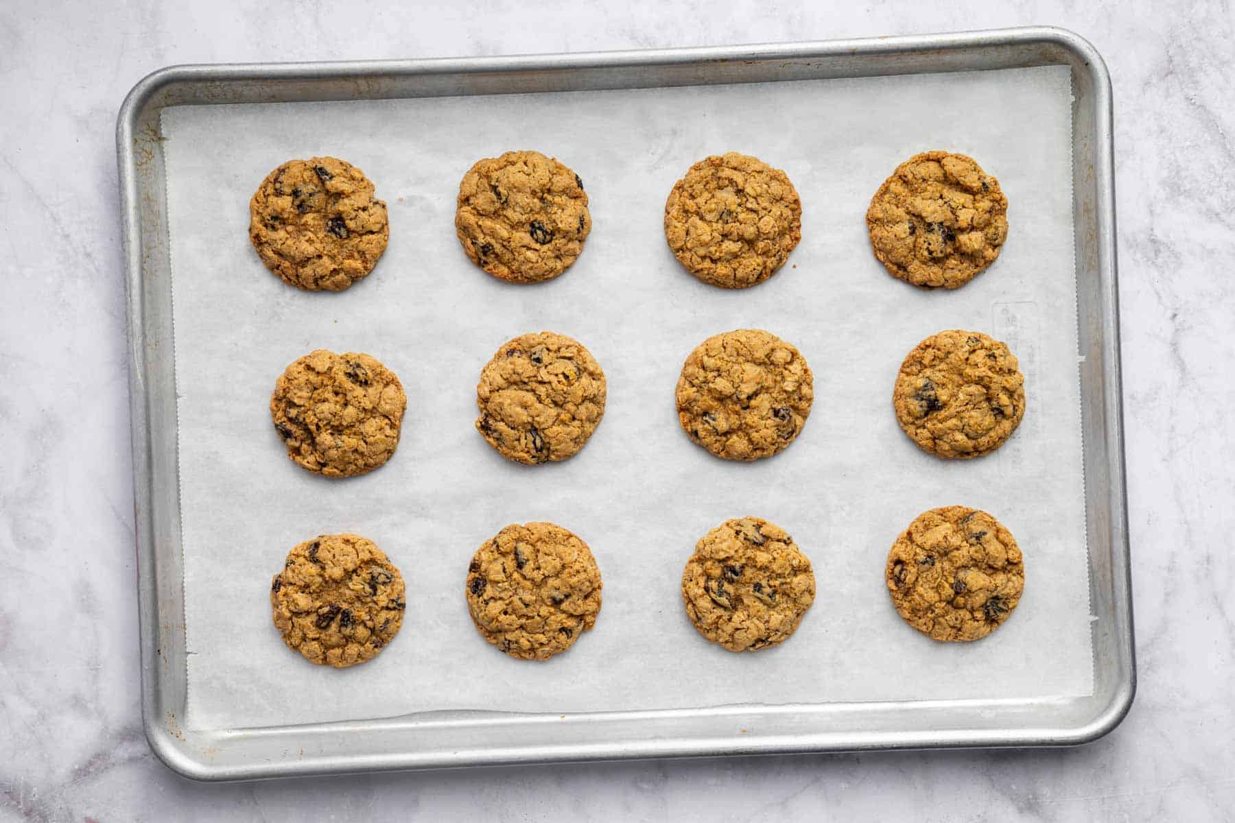 Twelve desserts evenly spaced on a parchment paper lined baking sheet.