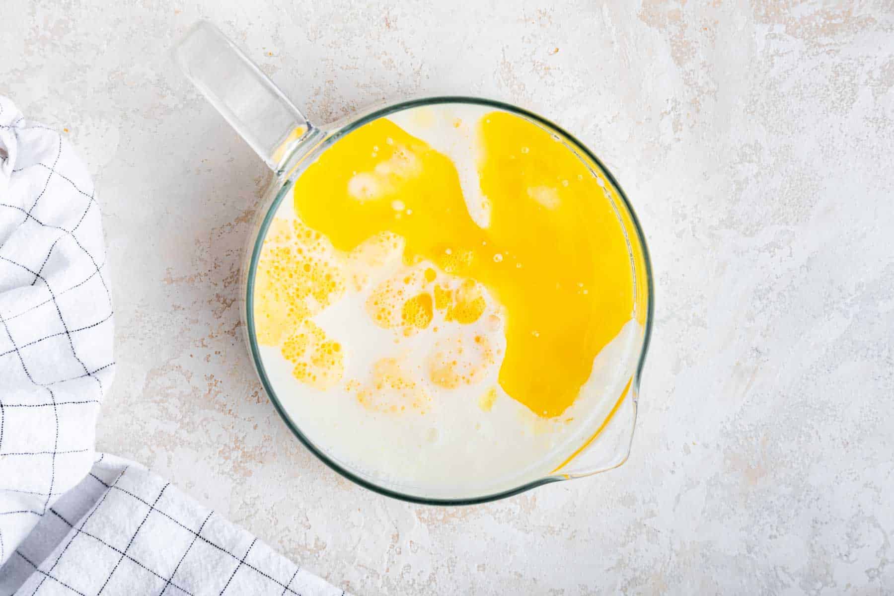 Glass measuring cup with butter and buttermilk.