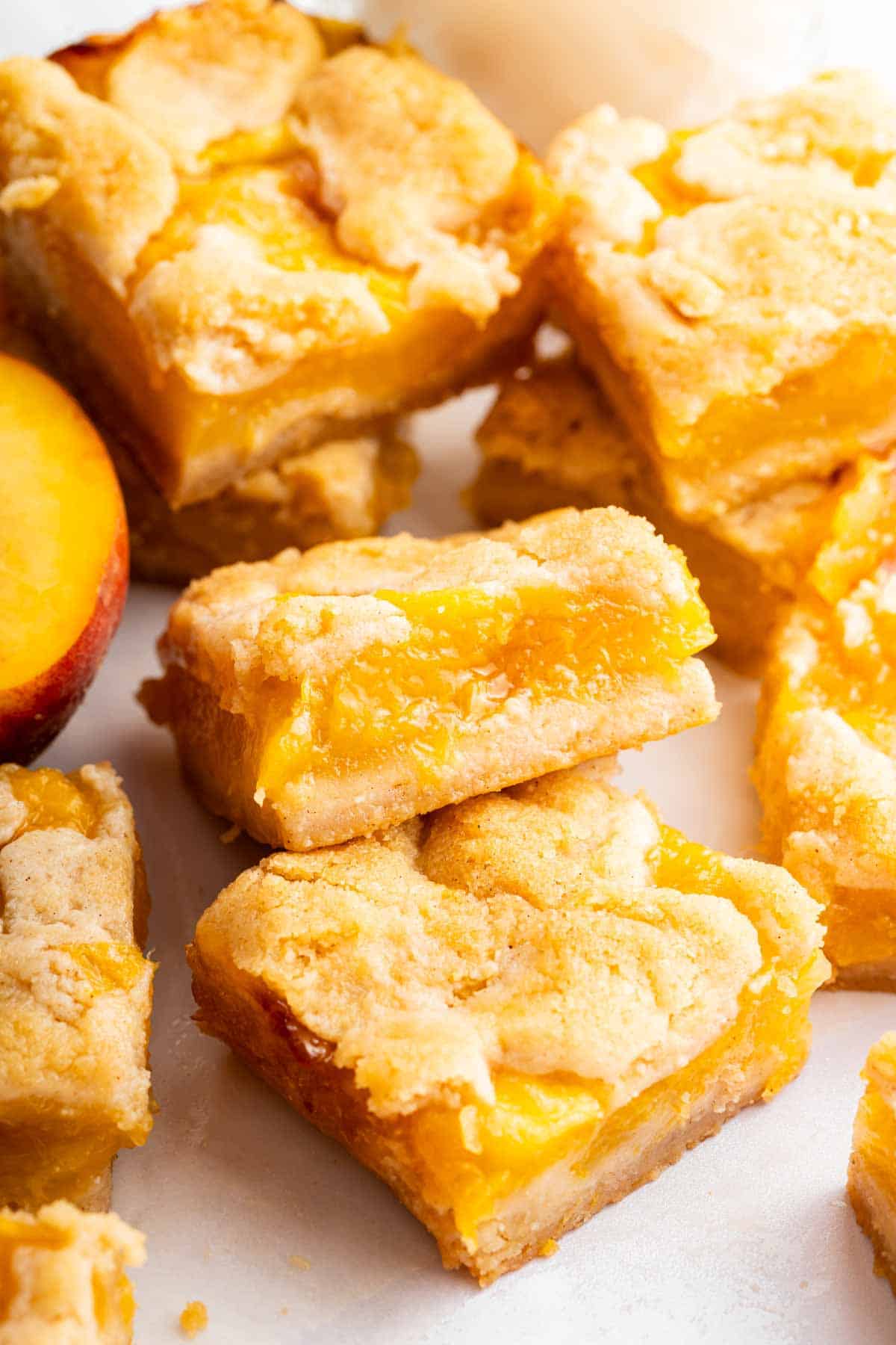 Sliced peach pie bars stacked on a cutting board.