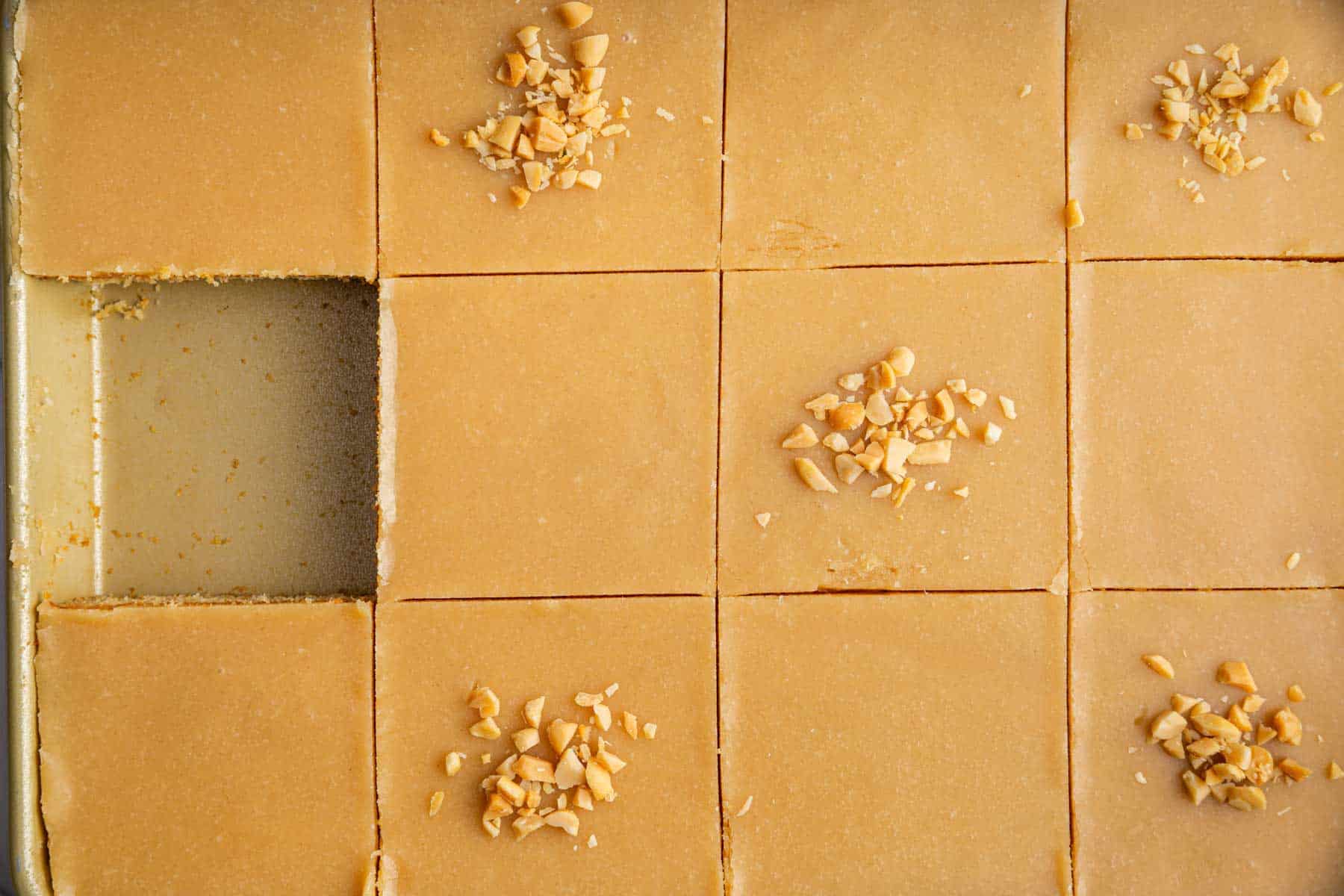 Square slices of brown cake garnished with crushed nuts.